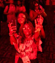 Two guests dancing under the red lights of the after party.