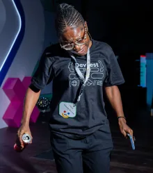 A guest in a DevFest tee on the floor under purple light.