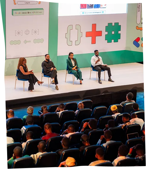 A four-person panel seated on stage at DevFest Lagos, with the audience watching from the floor.
